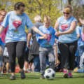 Student kicking soccer ball.