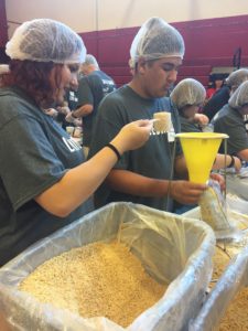 Students preparing meal packs for the needy.