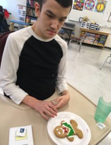 Student decorating a gingerbread cookie.